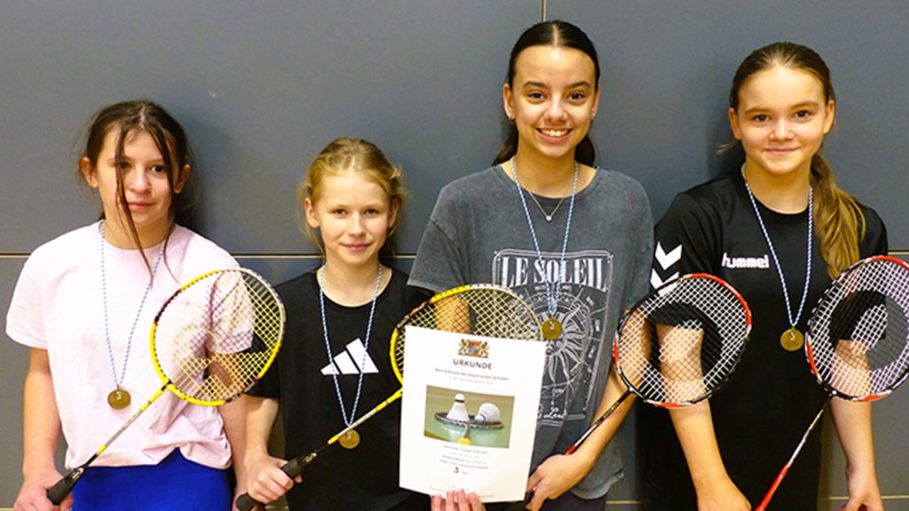 Schülerinnen mit Urkunde und Badmintonschlägern