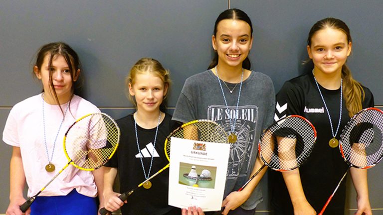 Schülerinnen mit Urkunde und Badmintonschlägern