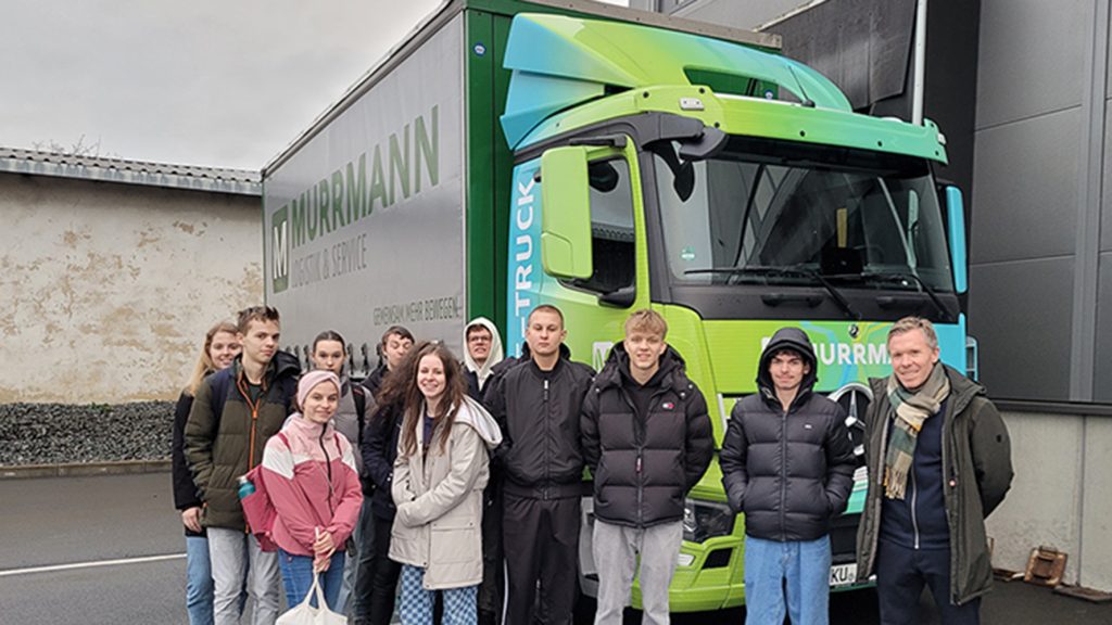 Schülergruppe auf dem Firmengelände vor LKW