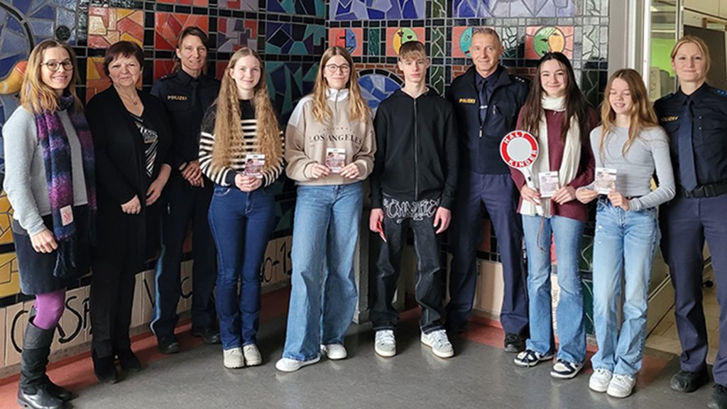 Schülerlotsinnen und Schülerlotsen mit Polizeibeamten