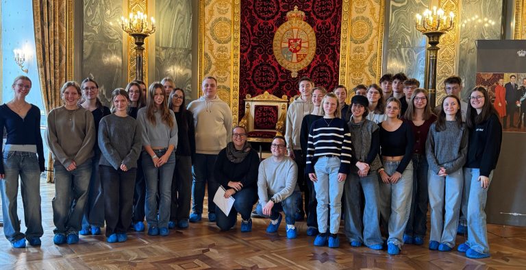 Schülerinnen und Schüler mit ihren Lehrkräften besichtigen einen Thronsaal