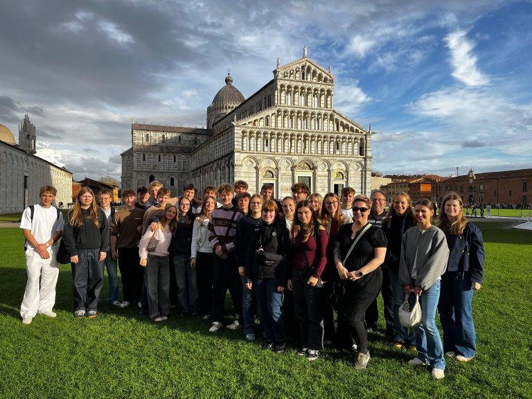 Schülerinnen und Schüler auf einer Wiese vor einem Gebäude
