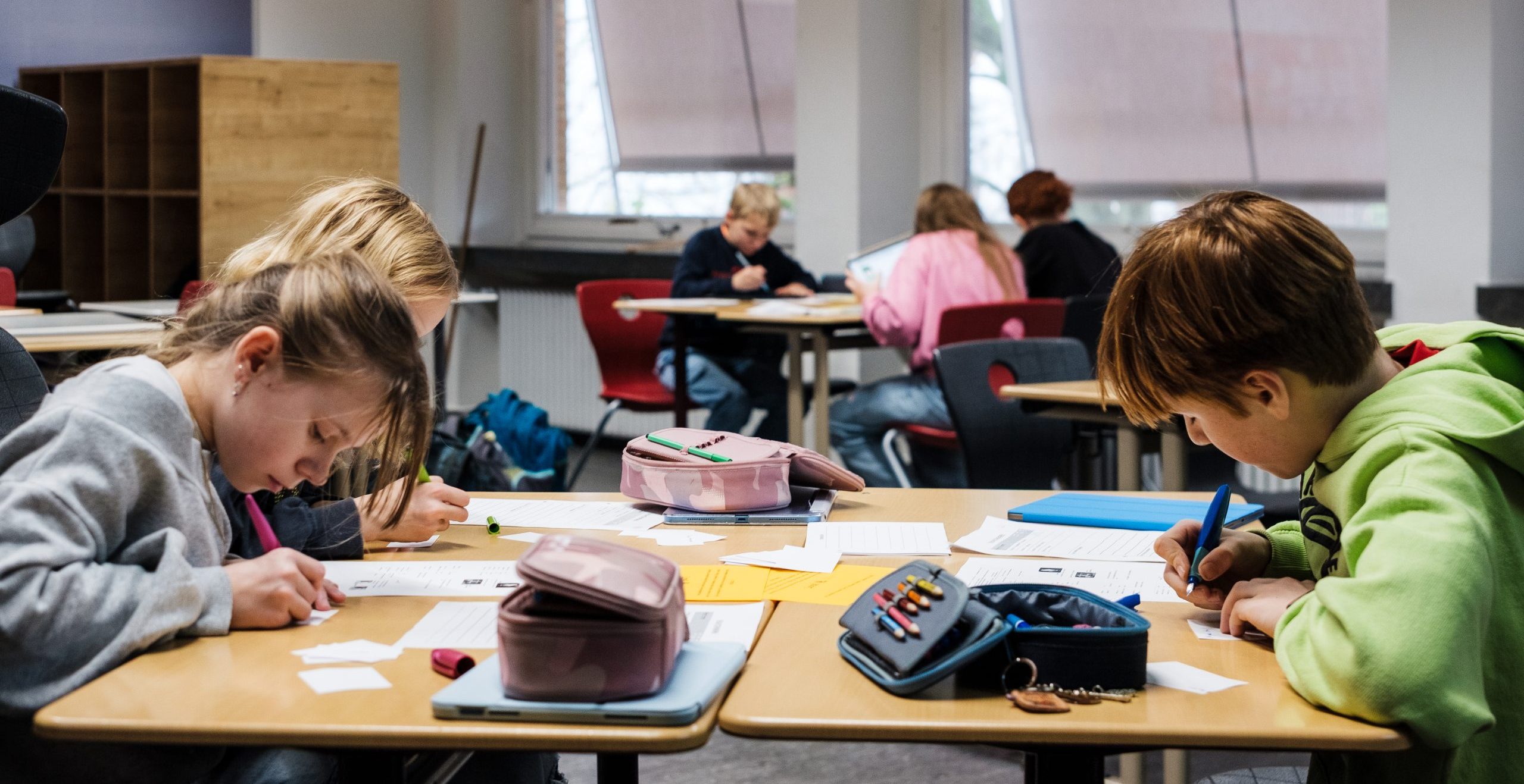 Schülerinnen und Schüler bearbeiten gemeinsam Aufgaben