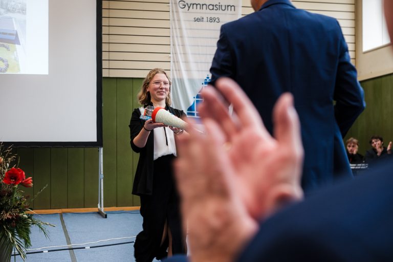 Schülersprecherin übergibt Schultüte als Geschenk an den neuen Schulleiter