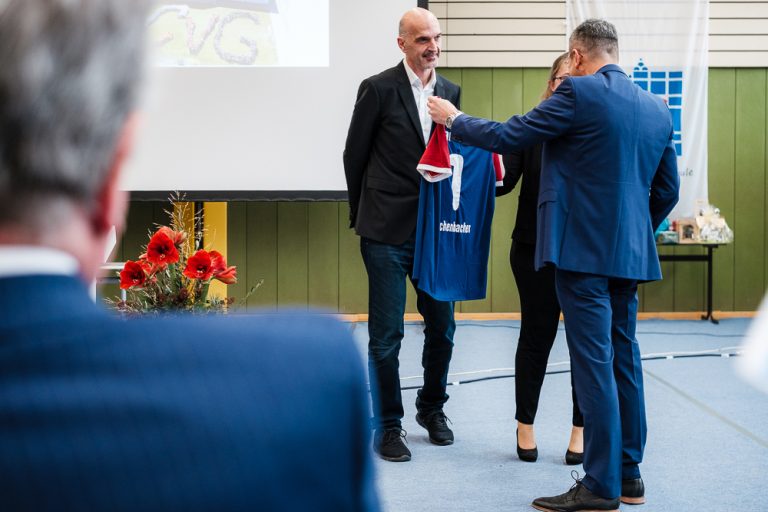 Ein CVG-Trikot wird als Geschenk an den neuen Schulleiter übergeben