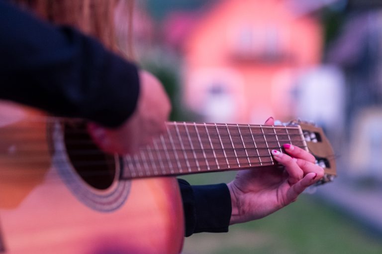 Nahaufnahme eines Gitarrenstegs beim Spielen