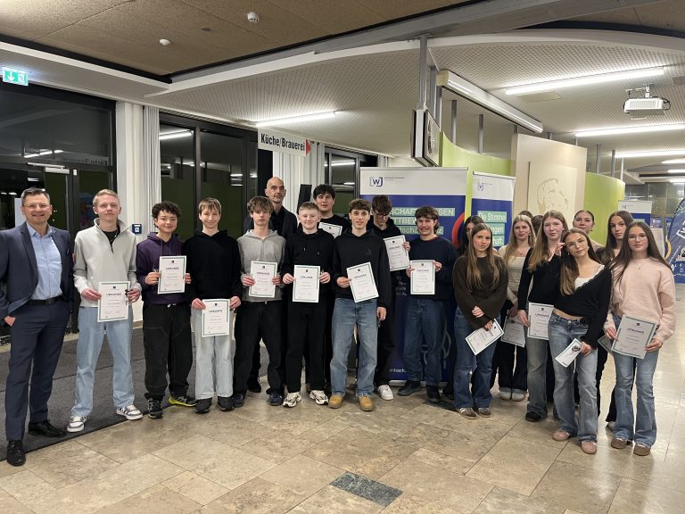 Schülerinnen und Schüler präsentieren ihre Urkunden über die Teilnahme am Wettbewerb Wirtschaftwissen