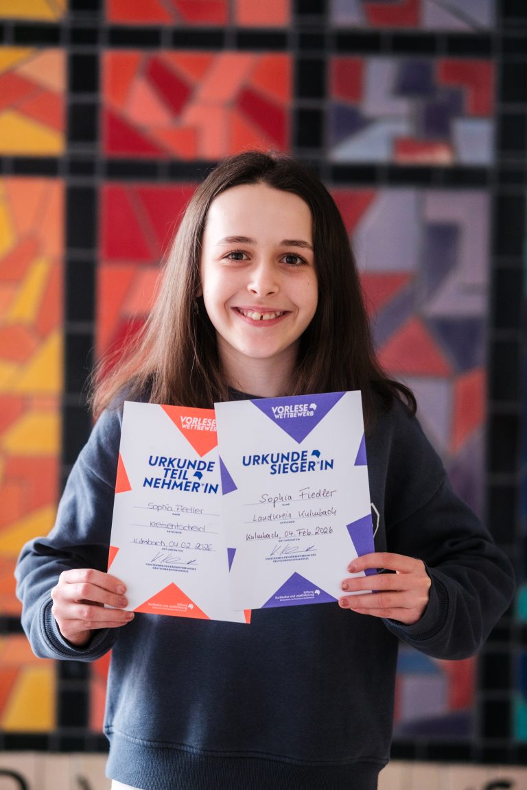 Schülerin präsentiert Teilnehmer- und Siegerurkunde vom Kreisentscheid