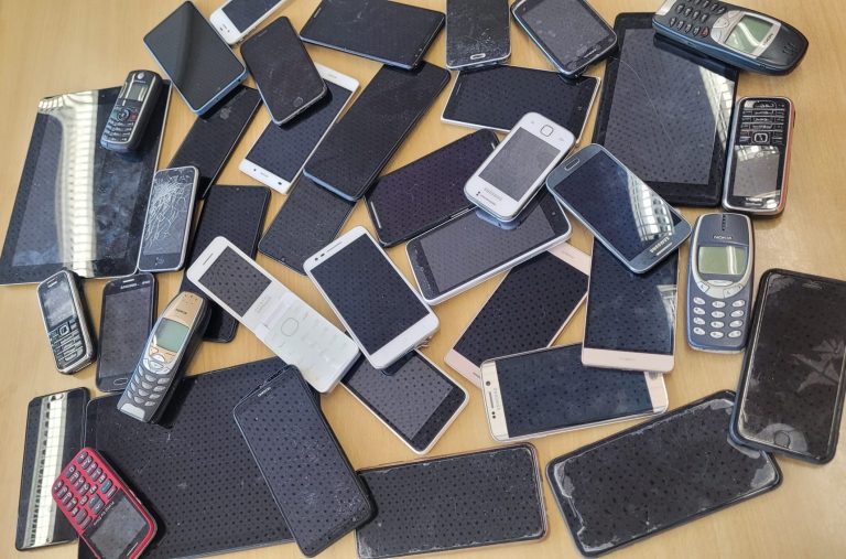 gesammelte alte Handys auf Tischplatte
