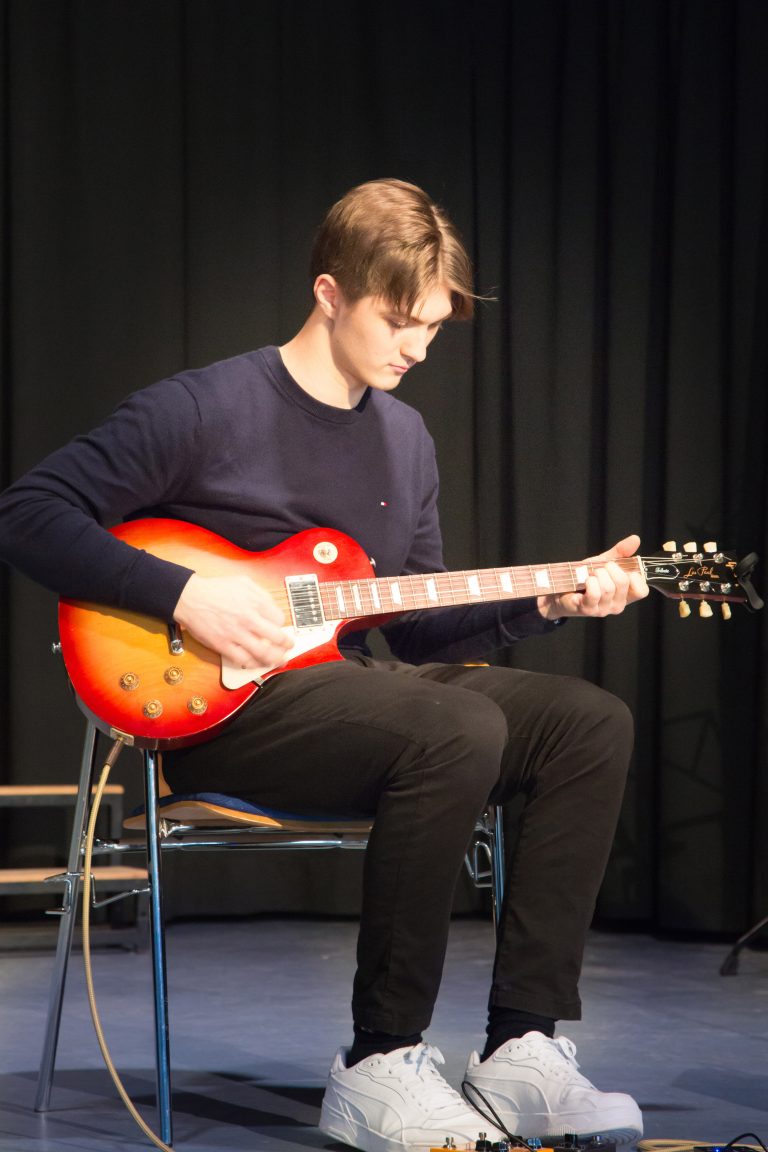 Schüler beim Gitarre spielen