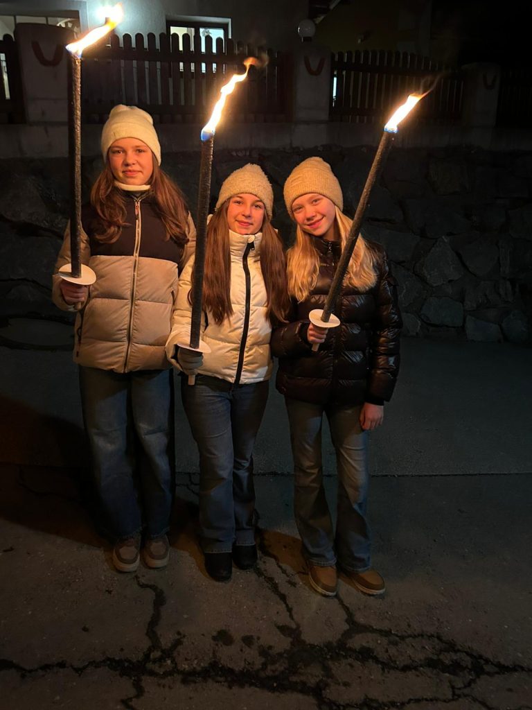 Schülerinnen halten Fackeln bei Nacht