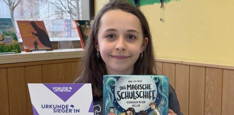 Schülerin präsentiert Urkunde und Buch