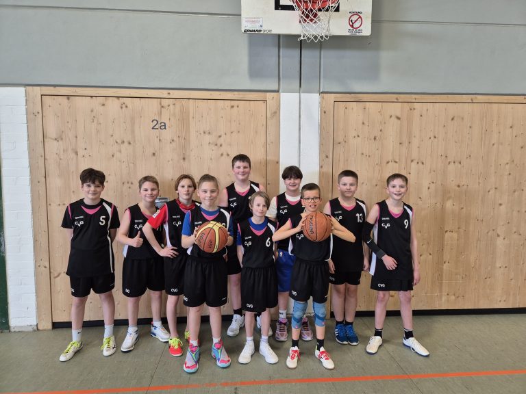 Gruppenfoto der Jungen der Basketballmannschaft in der Turnhalle