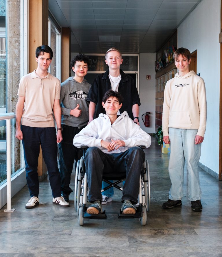 Gruppenfoto von Schülern, die die Zugänglichkeit des Schulgebäudes im Rollstuhl testen