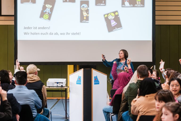 Die Beratungslehrkraft hält einen Infovortrag in der Turnhalle