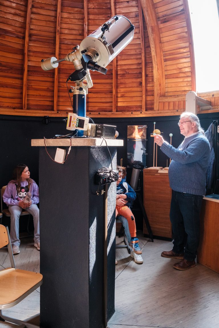 Lehrkraft präsentiert das Teleskop in der Sternwarte
