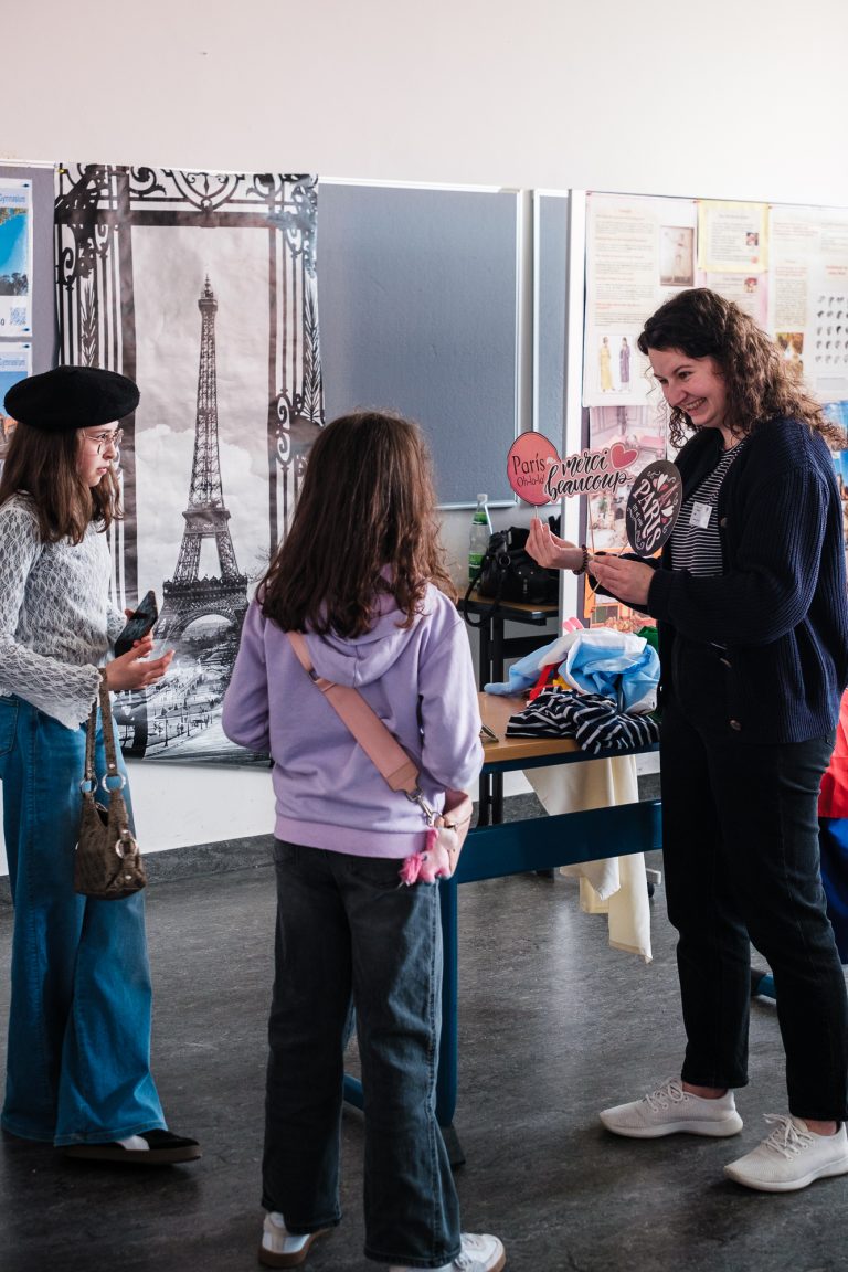 Lehrkraft im Gespräch mit Schülerinnen