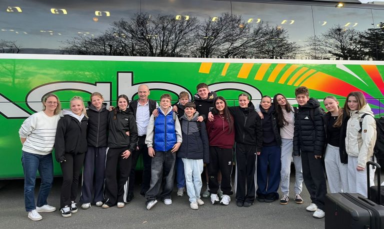 Gruppenbild der Schülerinnen und Schüler vor dem Reisebus