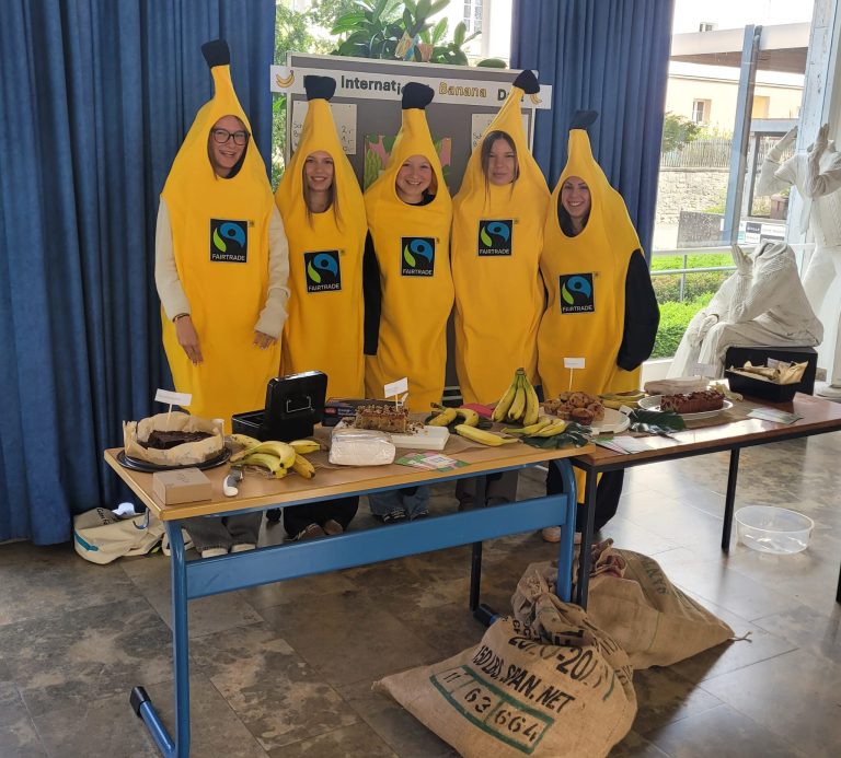 Schülerinnen im Bananenkostüm hinter ihrem Verkaufsstand