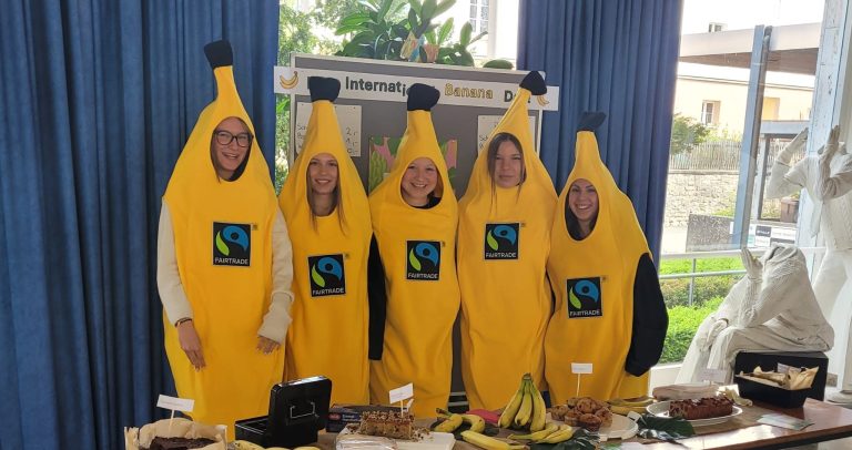 Schülerinnen im Bananenkostüm hinter ihrem Verkaufsstand
