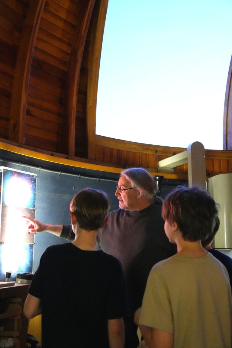 Lehrkraft erklärt Schülern Fotos in der Sternwarte