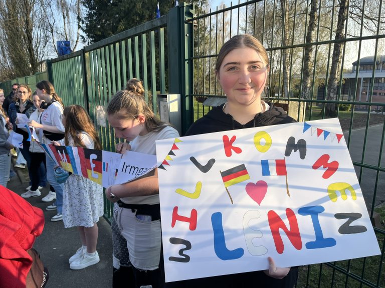 Schülerinnen mit Willkommens-Schildern