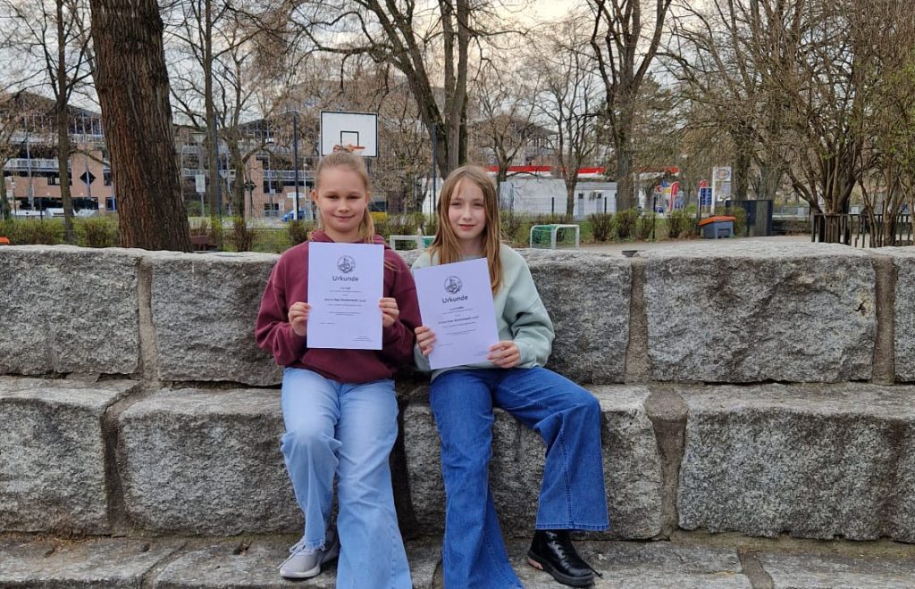 Schülerinnen präsentieren ihre Urkunden