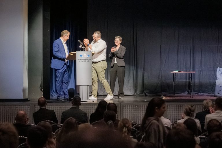 Grußworte vor Beginn des Theaterstücks auf der Bühne in der Stadthalle