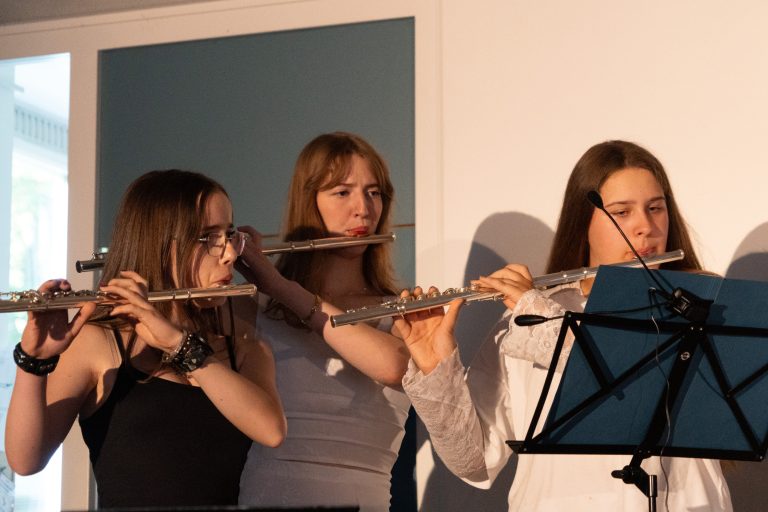Schülerinnen spielen Querflöte
