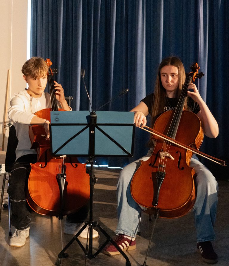 Schülerin und Schüler spielen Cello