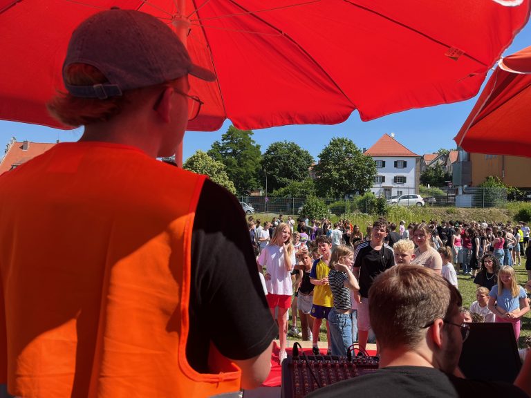 Abiturient erklärt Spiel vor Publikum aus Schülerinnen und Schülern