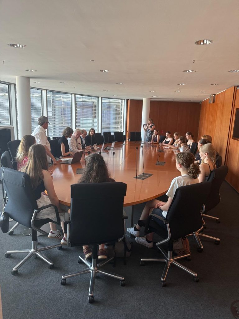 Schülerinnen und Schüler sitzen mit Bundesminister Rainer an Konferenztisch
