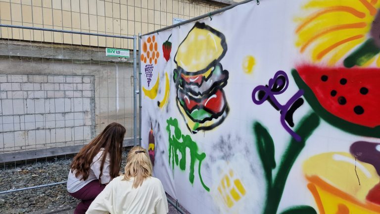Schülerinnen spryen Graffiti