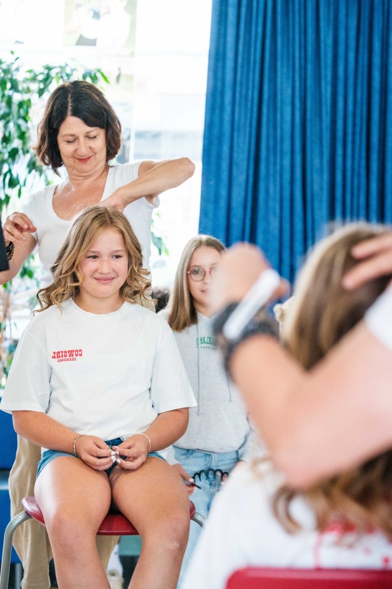 Friseurin schneidet Schülerin die Haare