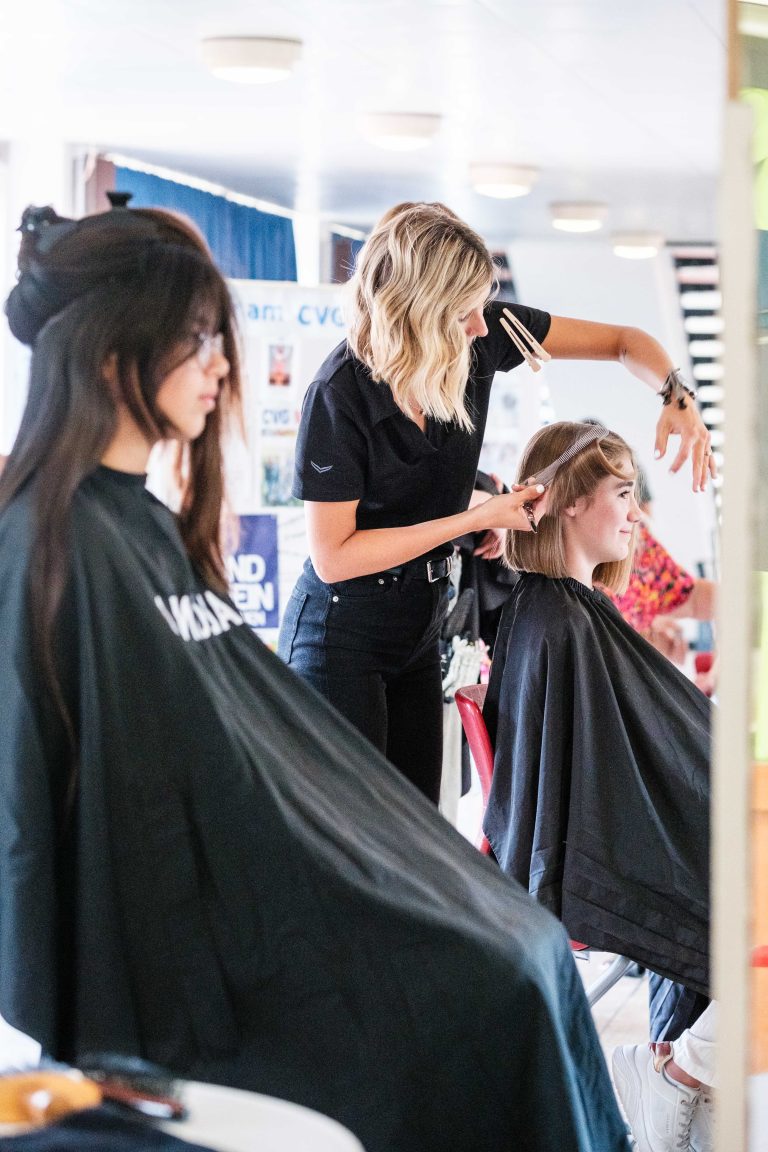 Friseurin schneidet Schülerin die Haare