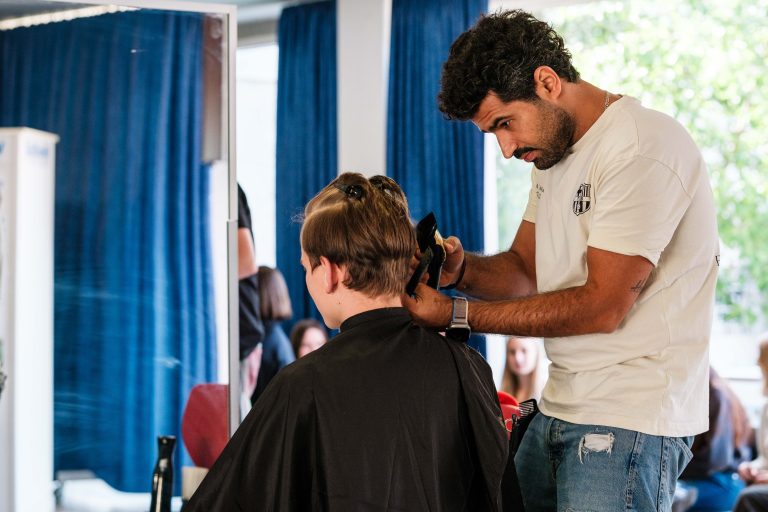 Friseur schneidet Schüler die Haare