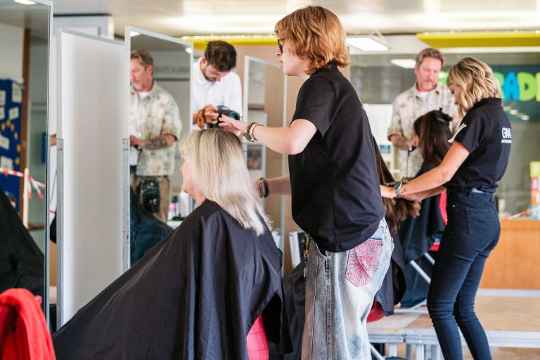 Friseurin schneidet Schülerin die Haare