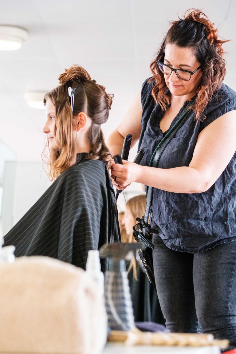 Friseurin schneidet Schülerin die Haare