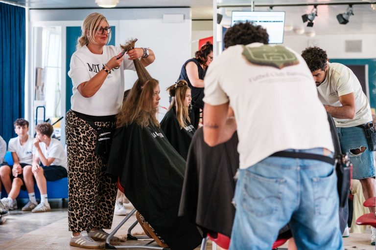 Friseurin schneidet Schülerin die Haare
