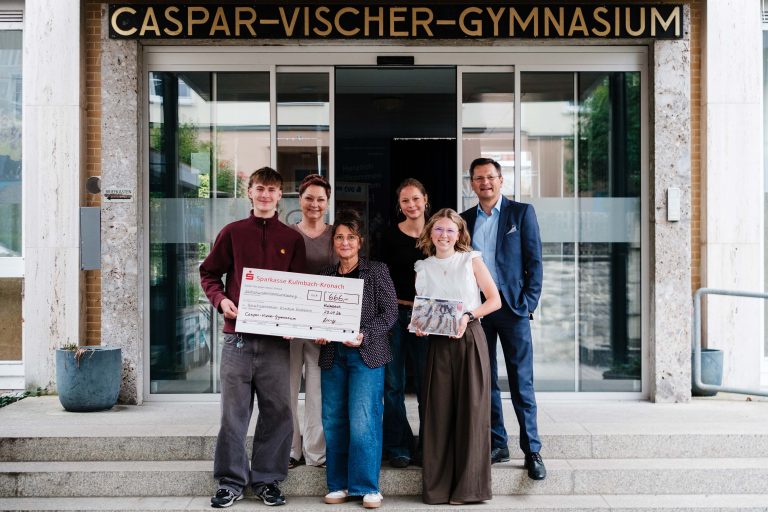 Übergabe des Spendenschecks vor dem Haupteingang des CVG