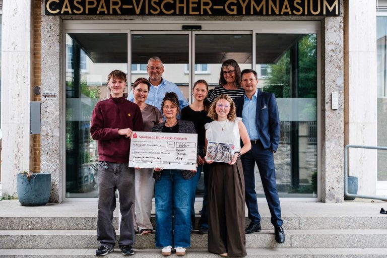 Übergabe des Spendenschecks vor dem Haupteingang des CVG