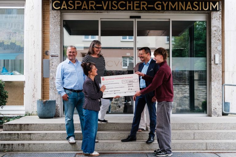 Übergabe des Spendenschecks vor dem Haupteingang des CVG