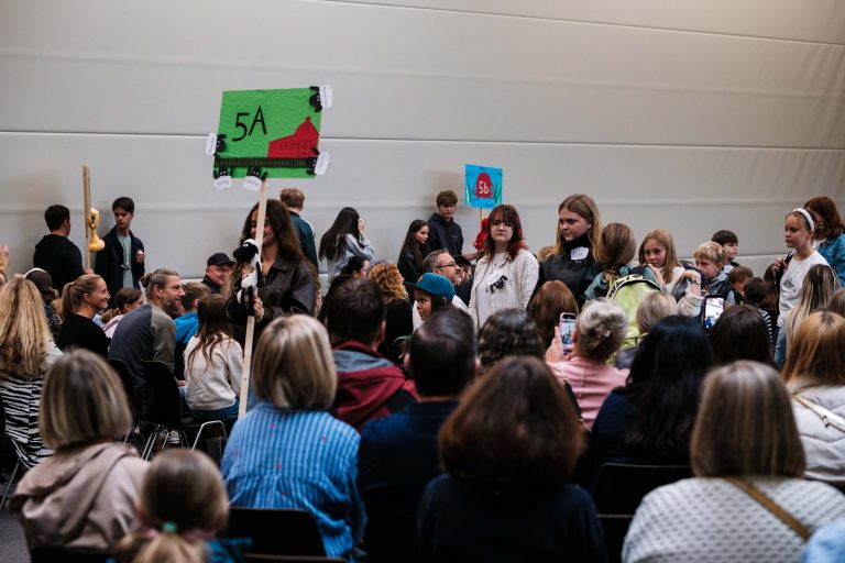 Tutoren führen ihre Klasse aus der Turnhalle ins Klassenzimmer