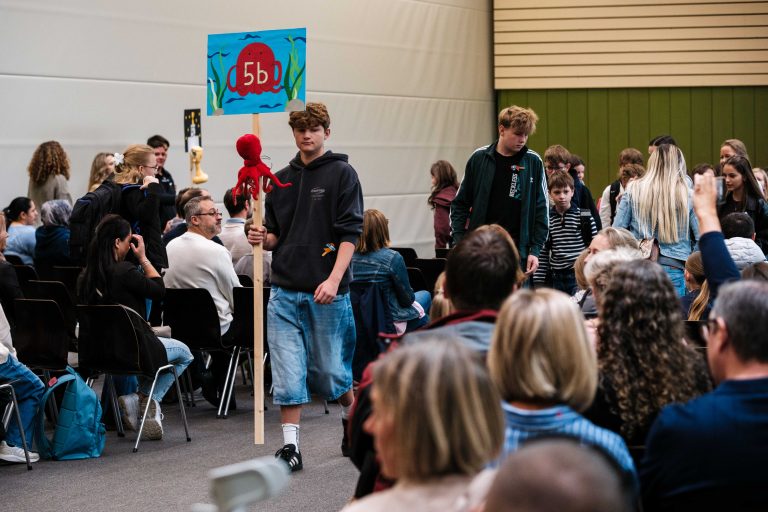 Tutoren führen ihre Klasse aus der Turnhalle ins Klassenzimmer